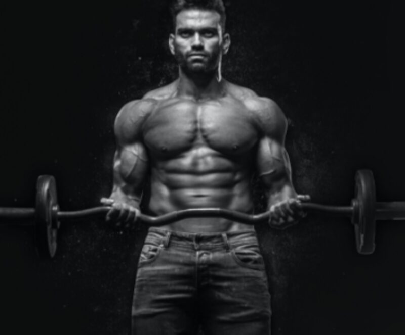 Black and white photo of a muscular man holding a barbell, representing body building training